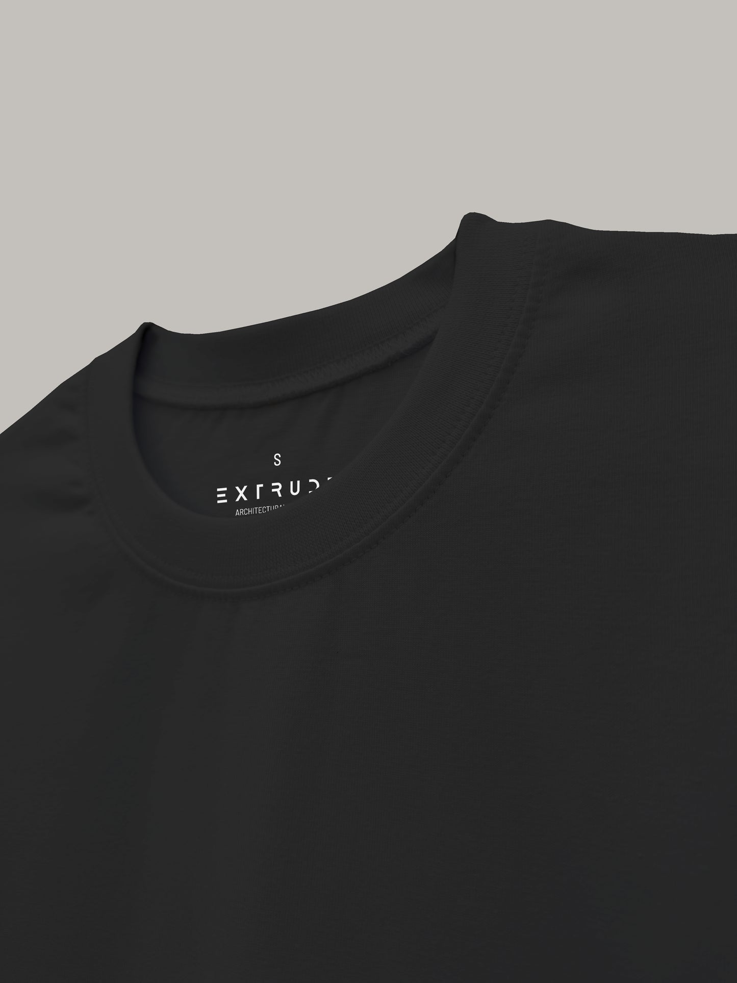 Detalle del cuello de camiseta oversize negra Extrude con etiqueta de marca