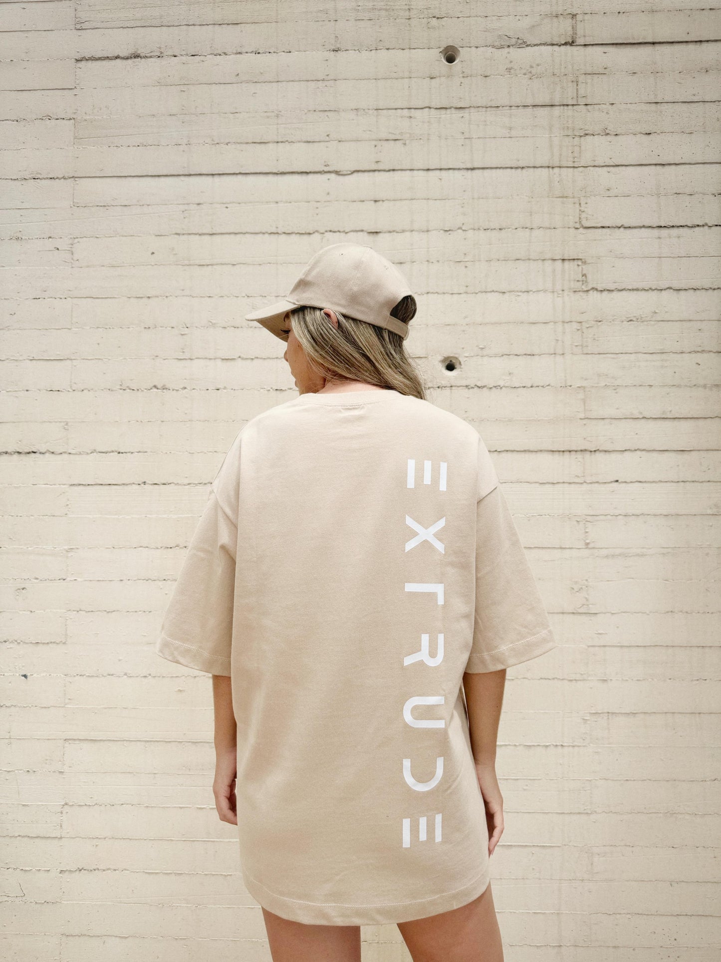Camiseta oversize beige Extrude Urban con logo vertical Extrude en la espalda – streetwear minimalista inspirado en arquitectura, moda urbana Colombia